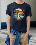 California Beach Vibes Tee Retro Sunset Sunglasses T-Shirt for West Coast Fans - model wearing navy shirt, hands in pockets