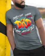 King Dad Attributes Tee Strong Loving Father’s Day T-Shirt Gift for Papa - model in grey shirt leaning against column