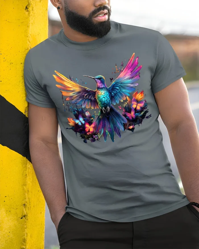 Vibrant Nature’s Flight Tee Rainbow Hummingbird with Flowers and Butterflies T-Shirt - model in grey shirt leaning against column