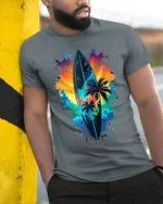 Colorful Surf Vibes T-Shirt Palm Tree and Sunset Graphic Tee for Summer Days - model in grey shirt leaning against column