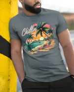 Chillin’ Beach Vibes T-Shirt Retro Palm Tree Sunset Tee for Summer Relaxation - model in grey shirt leaning against column