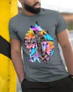 Christian Faith T-Shirt with Cross, Flowers, and Butterflies - model in grey shirt leaning against column