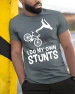 I Do My Own Stunts T-Shirt Funny Bike Fall Graphic Tee - model in grey shirt leaning against column