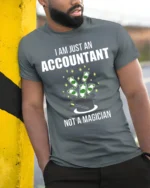 Funny Accountant T-Shirt Not a Magician Finance Tee - model in grey shirt leaning against column