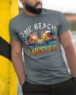 The Beach Is Calling T-Shirt Retro Summer Vacation Tee - model in grey shirt leaning against column