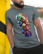 Watercolor Skull Stack Tee Vibrant Skull Art Graphic T-Shirt - model in grey shirt leaning against column