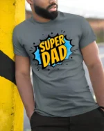 Superhero Dad T-Shirt Funny Father’s Day Tee Now - model in grey shirt leaning against column