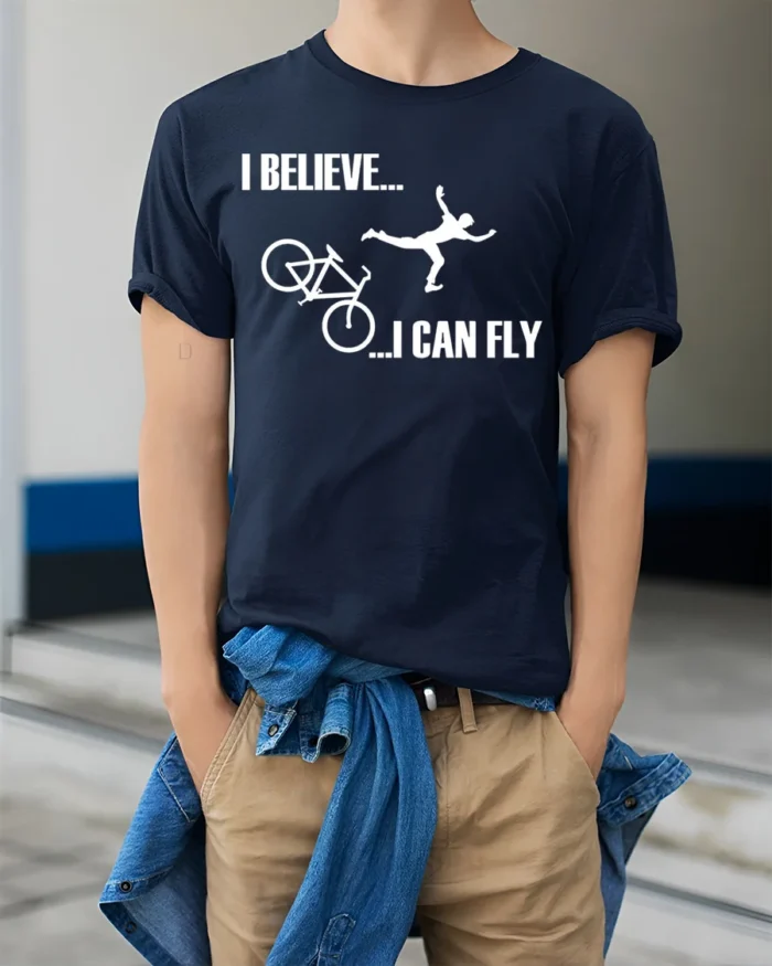 I Believe I Can Fly Funny Bike Crash T-Shirt for Cyclists - model wearing navy shirt, hands in pockets