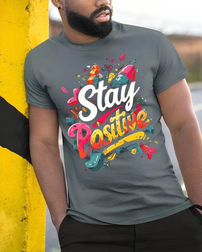 Stay Positive Motivational Graphic T-shirt for Men - model in grey shirt leaning against column