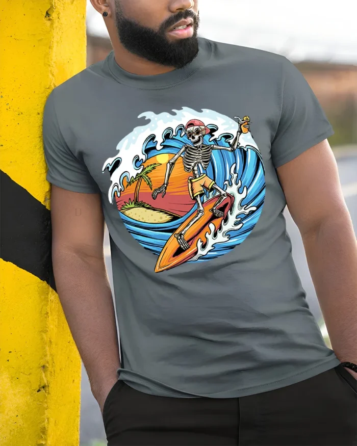 Skeleton Surfing Sunset T-shirt with Beach and Wave Art - model in grey shirt leaning against column