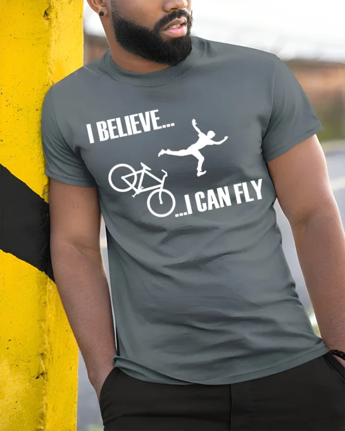 I Believe I Can Fly Funny Bike Crash T-Shirt for Cyclists - model in grey shirt leaning against column