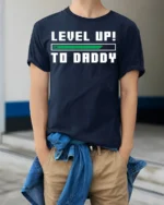 Level Up to Daddy T-Shirt Funny New Dad Gamer - model wearing navy shirt, hands in pockets