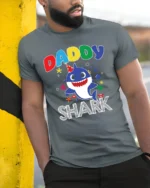 Daddy Shark Birthday T-Shirt for Family Party Fun - model in grey shirt leaning against column