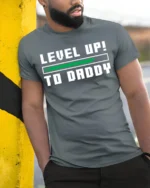 Level Up to Daddy T-Shirt Funny New Dad Gamer - model in grey shirt leaning against column