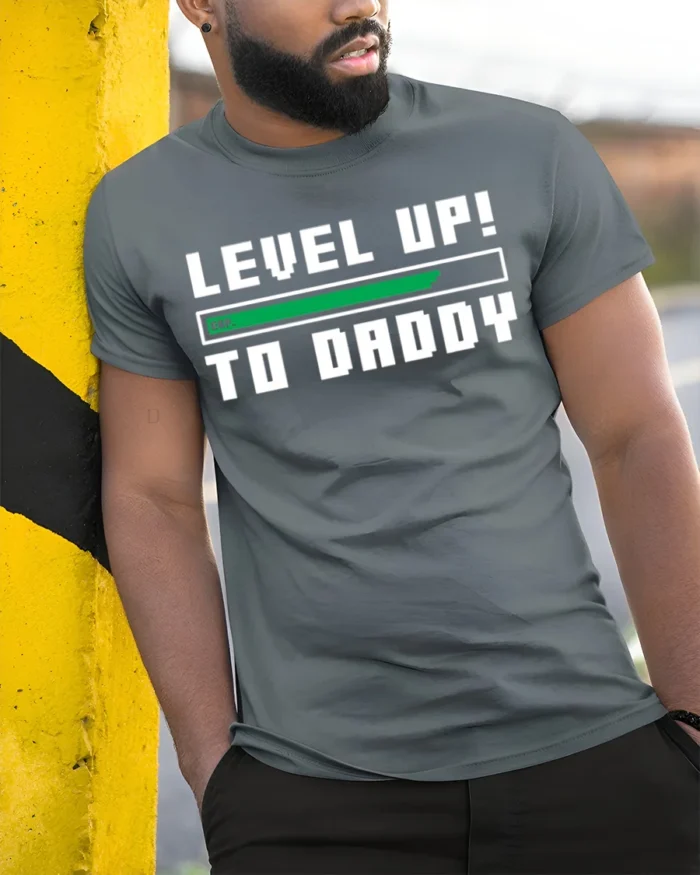 Level Up to Daddy T-Shirt Funny New Dad Gamer - model in grey shirt leaning against column