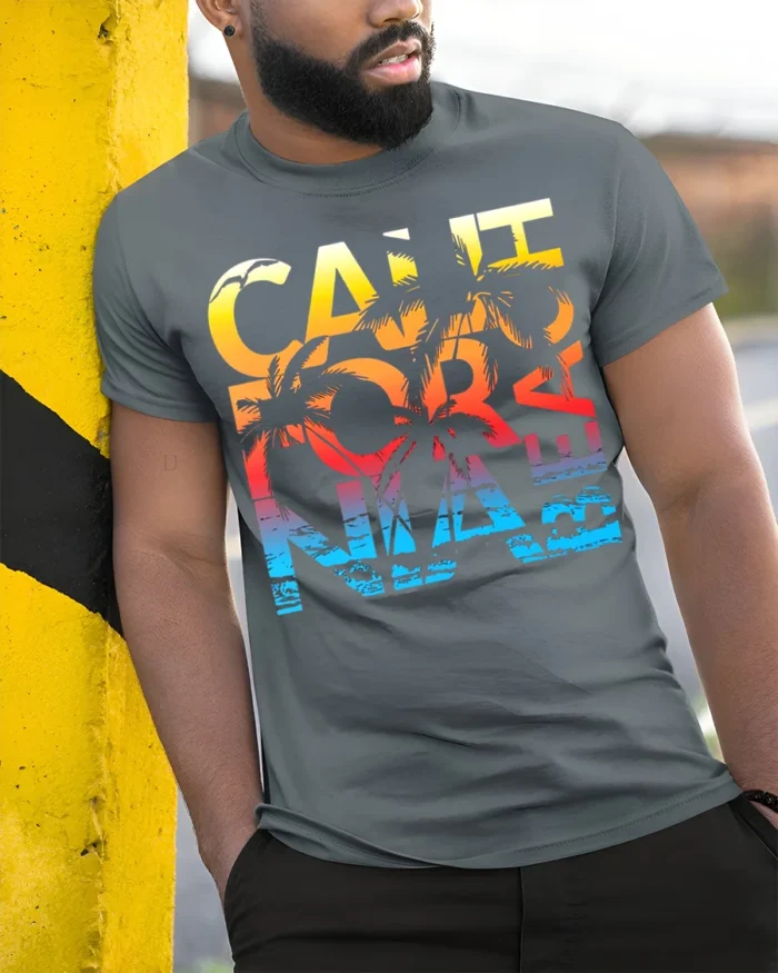 California Beach Sunset T-Shirt with Palm Tree Graphic - model in grey shirt leaning against column