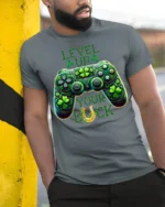 Level Up Your Luck Gaming T-Shirt with Shamrock Controller - model in grey shirt leaning against column