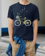 Starry Bicycle Ride T-Shirt Dreamy Bike Graphic - model wearing navy shirt, hands in pockets