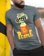 I Like Coffee More Than People Funny T-Shirt for Adults - model in grey shirt leaning against column
