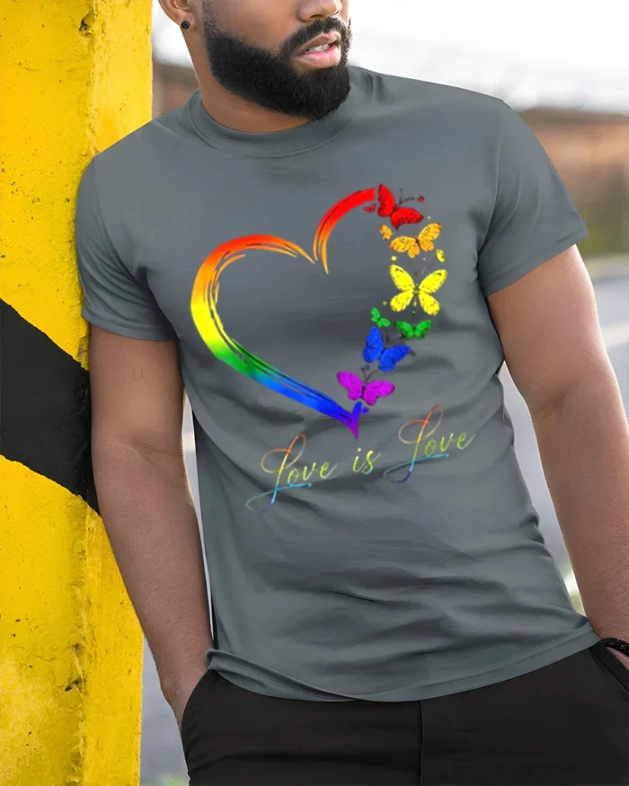 Love is Love Rainbow Heart Pride T-Shirt with Butterflies - model in grey shirt leaning against column