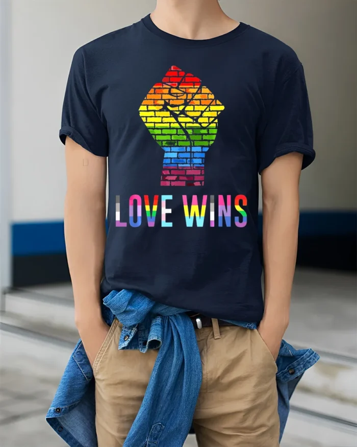Love Wins Rainbow Pride Fist T-Shirt LGBTQ Equality - model wearing navy shirt, hands in pockets