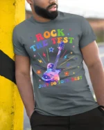 Rock the Test T-shirt Rainbow Guitar Motivational - model in grey shirt leaning against column