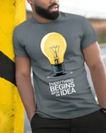 Everything Begins With an Idea Light Bulb T-Shirt - model in grey shirt leaning against column