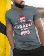 My Dad Is My Hero T-Shirt Funny Father’s Day Gift - model in grey shirt leaning against column