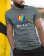 Love Is Love T-Shirt LGBTQ Rainbow Heart Pride - model in grey shirt leaning against column