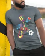 Be Different T-Shirt with Music, Art, and Sports Design - model in grey shirt leaning against column