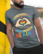 Be Kind Rainbow Heart Pride T-Shirt with Positive Message - model in grey shirt leaning against column