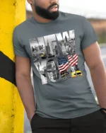 New York City Skyline T-Shirt with Statue and Flag Design - model in grey shirt leaning against column