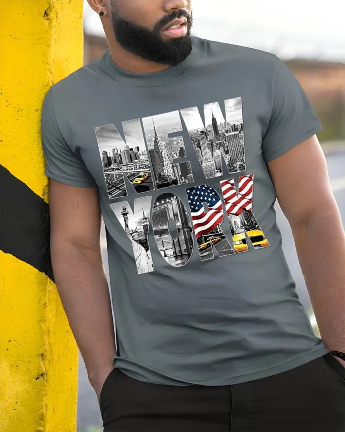 New York City Skyline T-Shirt with Statue and Flag Design - model in grey shirt leaning against column