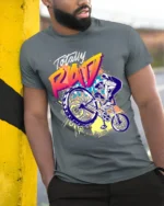 Totally Rad BMX Trick T-Shirt with 80s Retro Vibe Design - model in grey shirt leaning against column