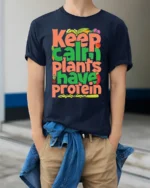 Keep Calm Plants Have Protein T-Shirt Vegan Message - model wearing navy shirt, hands in pockets