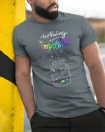 Nothing Is Impossible Rainbow Galaxy T-Shirt for Dreamers - model in grey shirt leaning against column