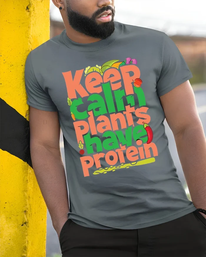 Keep Calm Plants Have Protein T-Shirt Vegan Message - model in grey shirt leaning against column