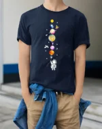 Cute Astronaut Holding Planets Balloon Galaxy T-Shirt - model wearing navy shirt, hands in pockets