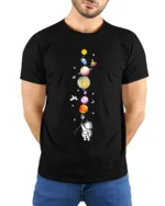 Cute Astronaut Holding Planets Balloon Galaxy T-Shirt - model wearing black shirt, hands behind back