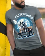 Overthinking Skeleton Sitting on Bench Graphic T-Shirt - model in grey shirt leaning against column