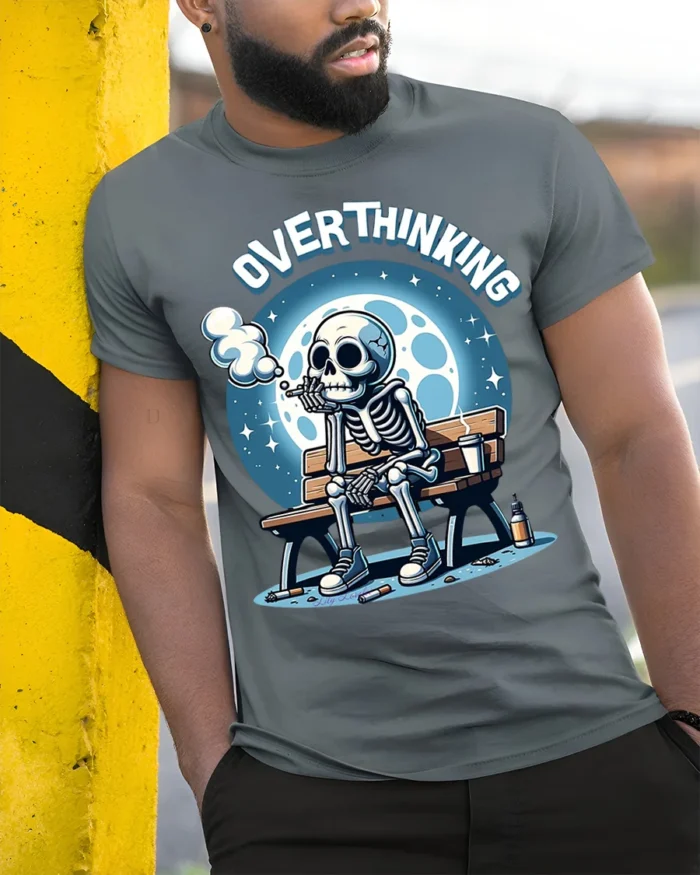Overthinking Skeleton Sitting on Bench Graphic T-Shirt - model in grey shirt leaning against column