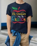 My Students Are The Reason Teacher Apple T-Shirt - model wearing navy shirt, hands in pockets