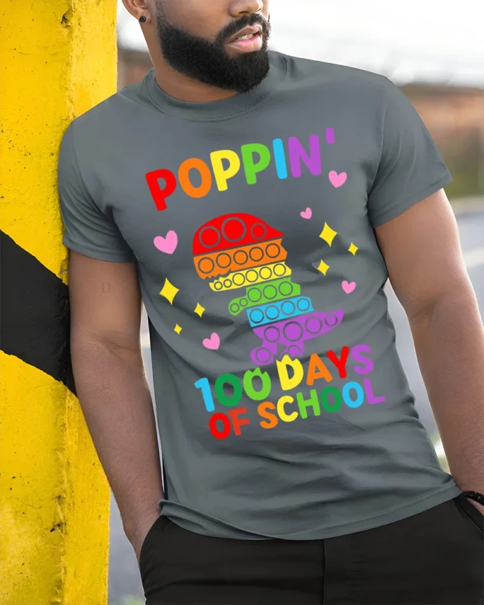 Colorful Dino Pop It 100 Days School T-Shirt - model in grey shirt leaning against column