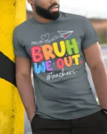 Funny Teacher Bruh We Out T-Shirt for Last Day Vibes - model in grey shirt leaning against column