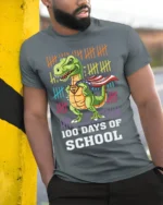 100 Days of School Dinosaur Superhero T-Shirt - model in grey shirt leaning against column
