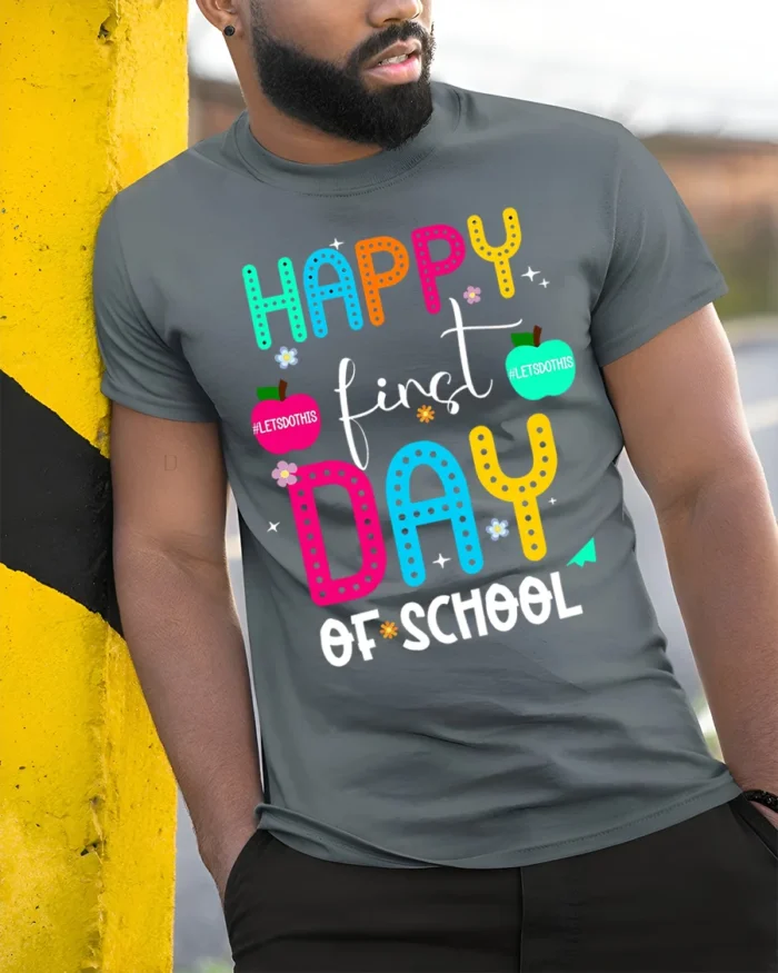 Happy First Day of School Colorful Teacher T-Shirt - model in grey shirt leaning against column