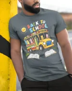 Cute Back to School T-Shirt with Bus and Pencils - model in grey shirt leaning against column