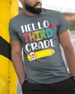 Hello Third Grade T-Shirt Cute Back to School Tee - model in grey shirt leaning against column