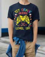 1st Grade Unlocked Gamer Back to School T-shirt - model wearing navy shirt, hands in pockets