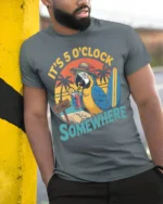 It’s 5 O’Clock Somewhere Beach T-Shirt - model in grey shirt leaning against column